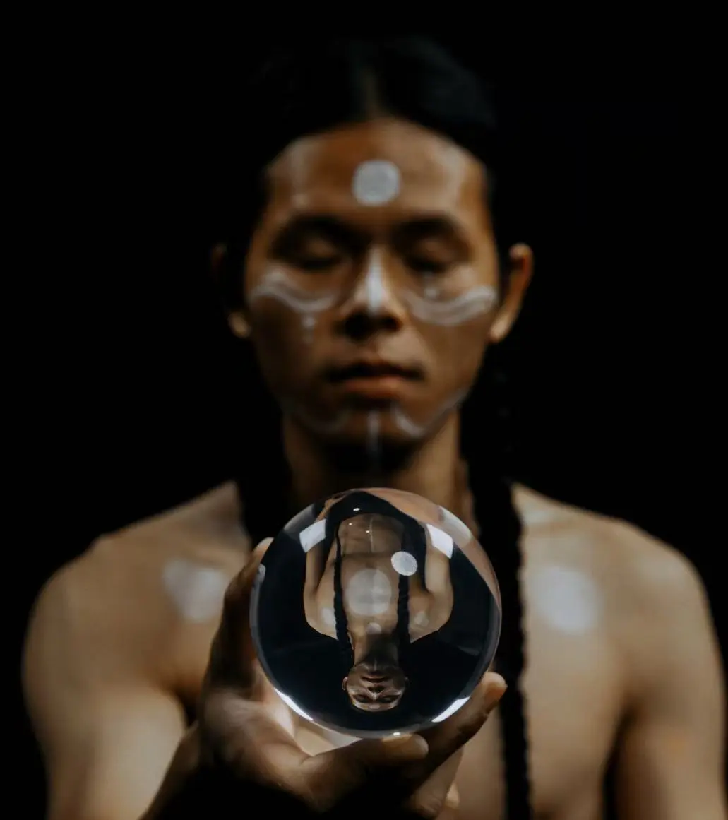 傅观手持水晶球，球体中映出倒置的人像
